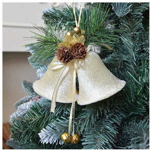 Close-up of cream gold Christmas tree bells with pine cones and berries on green pine needles