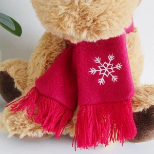 Plush reindeer toy with festive red snowflake scarf and fringe details for Christmas