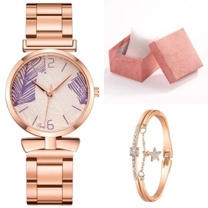 Detail of rose gold watch with palm leaf dial, star charm bracelet, and pink gift box