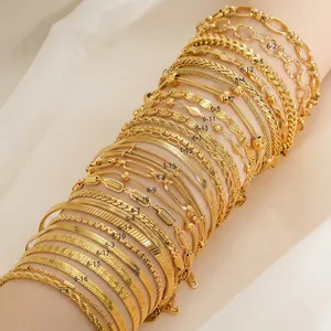 Variety of luxury 18K gold plated stainless steel anklets and chains displayed on white rolls