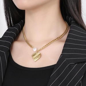 Close-up of vintage gold heart pendant necklace with pearl on a professional model