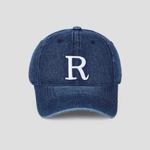 Détail d'une casquette de baseball en jean vintage avec broderie 3D de la lettre R blanche