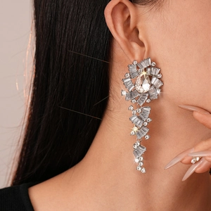 Close-up of luxury silver drop earrings with sparkling rhinestones worn by a model
