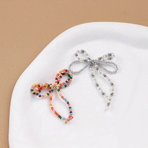 Handmade beaded bow jewelry accessories with colorful and pearlescent beads in a dish