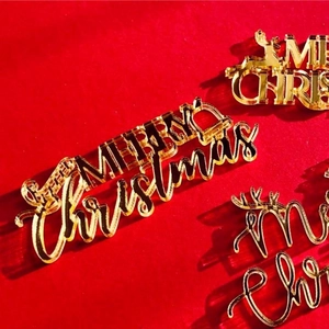 Macro view of golden mirror acrylic Merry Christmas cake toppers on red velvet