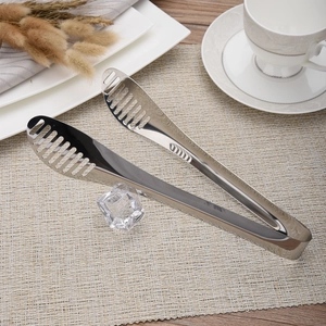 Stainless steel food tongs with hollow head on beige placemat for BBQ and steak