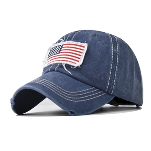 Detail of distressed navy cotton baseball cap with embroidered flag and frayed brim