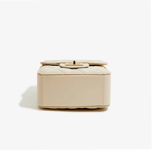 Detail view of beige quilted leather handbag with gold twist lock and base structure