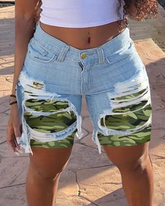 Detailed view of women's light blue ripped denim shorts with camouflage patchwork lining