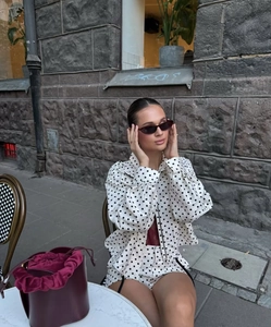 Polka dot two-piece set featuring long-sleeved jacket and high-waisted shorts in white