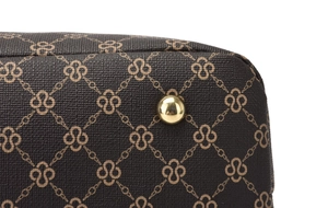 Detailed macro view of the dark brown patterned handbag bottom with gold metal feet