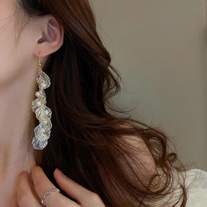 Boucles d'oreilles élégantes fleurs en acrylique et perles sur un modèle