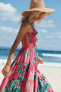 Close-up of pink tropical print sundress featuring smocked bodice and tiered hem details