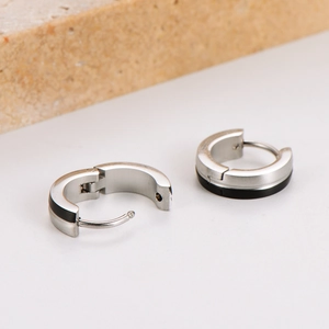 Minimalist silver and black stainless steel hoop earrings on natural stone background