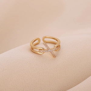Elegant gold-plated adjustable cross ring with zircon stones on soft beige fabric