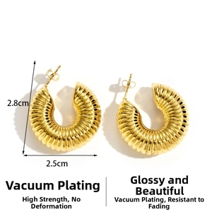 Detailed view of chunky gold-plated C-shaped hoop earrings with ribbed croissant texture