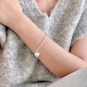 Minimalist 925 sterling silver heart charm bracelet with olive bead chain on a wrist
