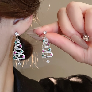 Detail of Christmas tree stud earrings with zircon crystals and colorful gems on ear