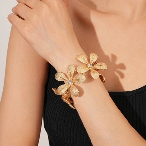 Detailansicht eines goldenen Blumenarmbands mit Strassmitte und gebürsteter Metallstruktur