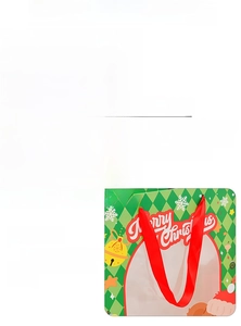 Detailed view of Christmas gift bag with festive bear pattern and red satin ribbon handles