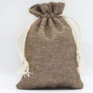 Rustic brown linen drawstring jewelry bag with cotton ropes on a white background