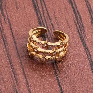 Close-up of golden multi-layer ring with star patterns and sparkling micro-inlaid zircons