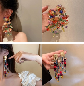 Detalle de pendientes florales con cuentas de resina coloridas y aleación de metal dorado
