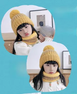 Dettaglio del set cappello e sciarpa in maglia gialla per bambini con pompon