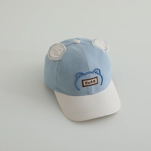 Détail d'une casquette bébé avec oreilles d'ours et écusson brodé Cute sur le devant