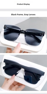 Detail of rimless square sunglasses with grey lenses and white leather pouch