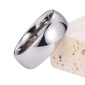 Bague en acier tungstène argenté poli avec surface bombée sur un support en pierre