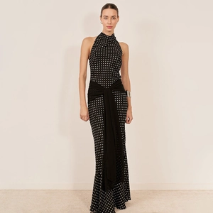 Elegant black polka dot halter neck dress with waist ribbon and long flowing silhouette