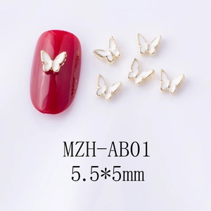 Detailed close-up of 5.5x5mm gold-edged butterfly nail charms with white oil filling