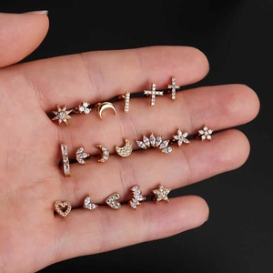 Detailed view of seventeen gold 925 silver stud earrings with zircon in a hand