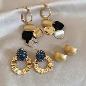 Three elegant vintage-style bow and flower stud earrings on premium champagne silk fabric