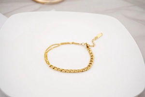 Detailed view of a gold-plated stainless steel hybrid cuban link and bead chain bracelet
