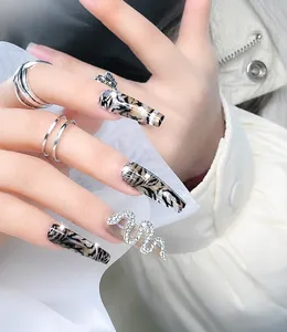 Macro shot of 3D snake nail charm with zircon stones on leopard print fake nails