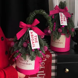Mini Christmas flower box with two frosted pine trees, pink ribbons and star chains