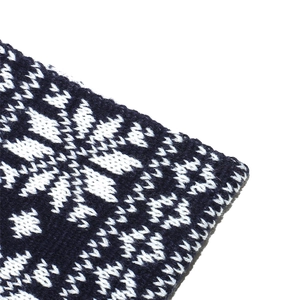 Détail du motif flocon de neige tricoté bleu marine sur tissu doux en laine mélangée