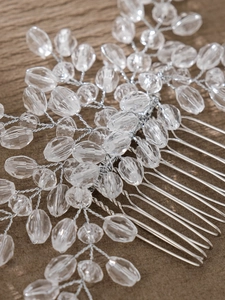 Macro shot of silver bridal hair comb featuring handmade crystals and delicate pearl beads