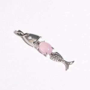 Detailed close-up of a silver fish pendant with pink gemstone and small white pearl