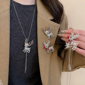 Detail of silver reindeer necklace and brooch set with red and clear rhinestones