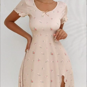 Robe courte fleurie ajustée avec nœud au col rond et fente latérale en rose