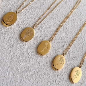 Detailed close-up of 18K gold stainless steel pendants with engraved flower patterns