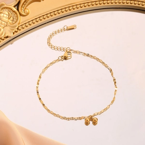 Minimalist gold titanium steel bead bracelet featuring double spheres on a mirrored surface