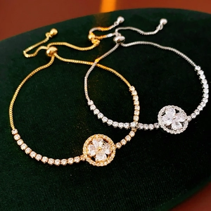 Detailed macro of gold and silver clover bracelets with zircon inlay on velvet background