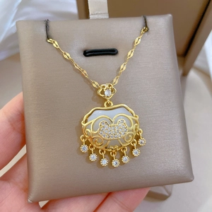 Detail of gold tassel lock necklace with white jade inlay and sparkling rhinestones