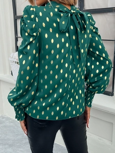 Back view of dark green long sleeve blouse with gold polka dots and bow tie neckline
