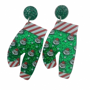 Detail of Christmas green glitter glove earrings with Santa Claus pattern on white backdrop
