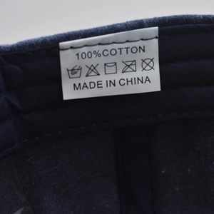 Macro view of 100% cotton washing label and care symbols on a navy baseball cap